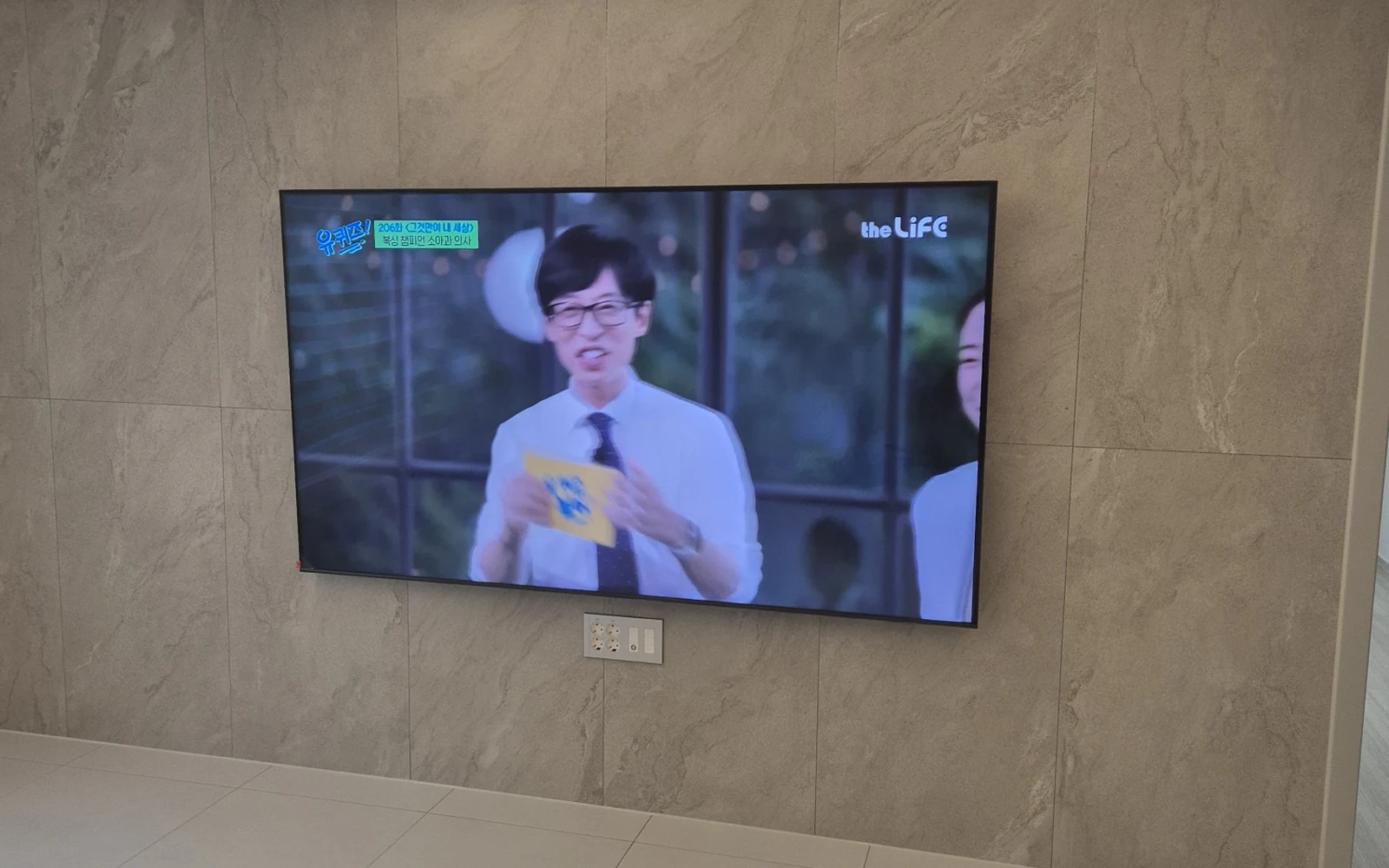 베이지 타일 벽면 TV 설치 사진